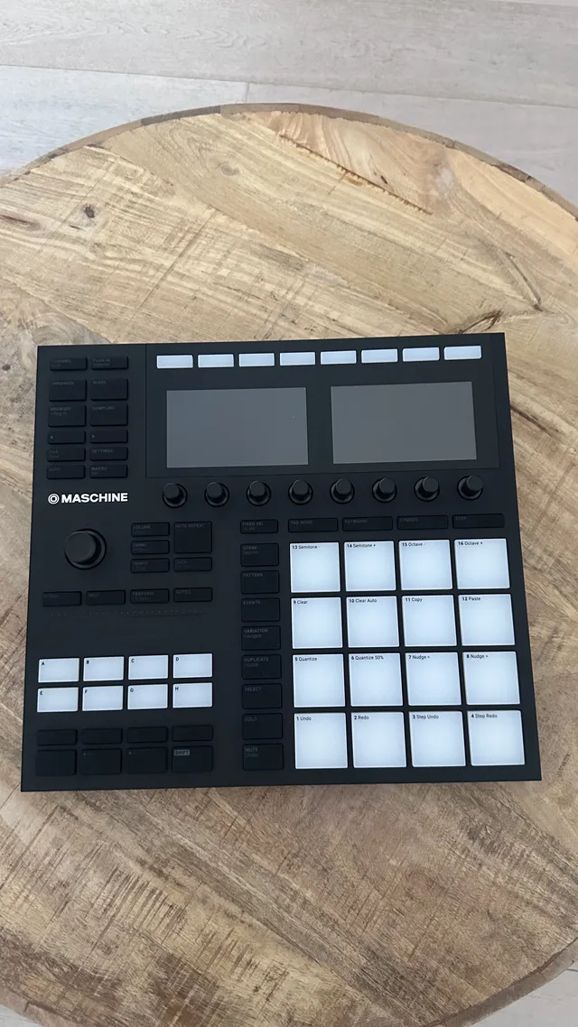 Native Instruments Maschine MK3 van bovenaf op een houten tafel, met een prijskaartje